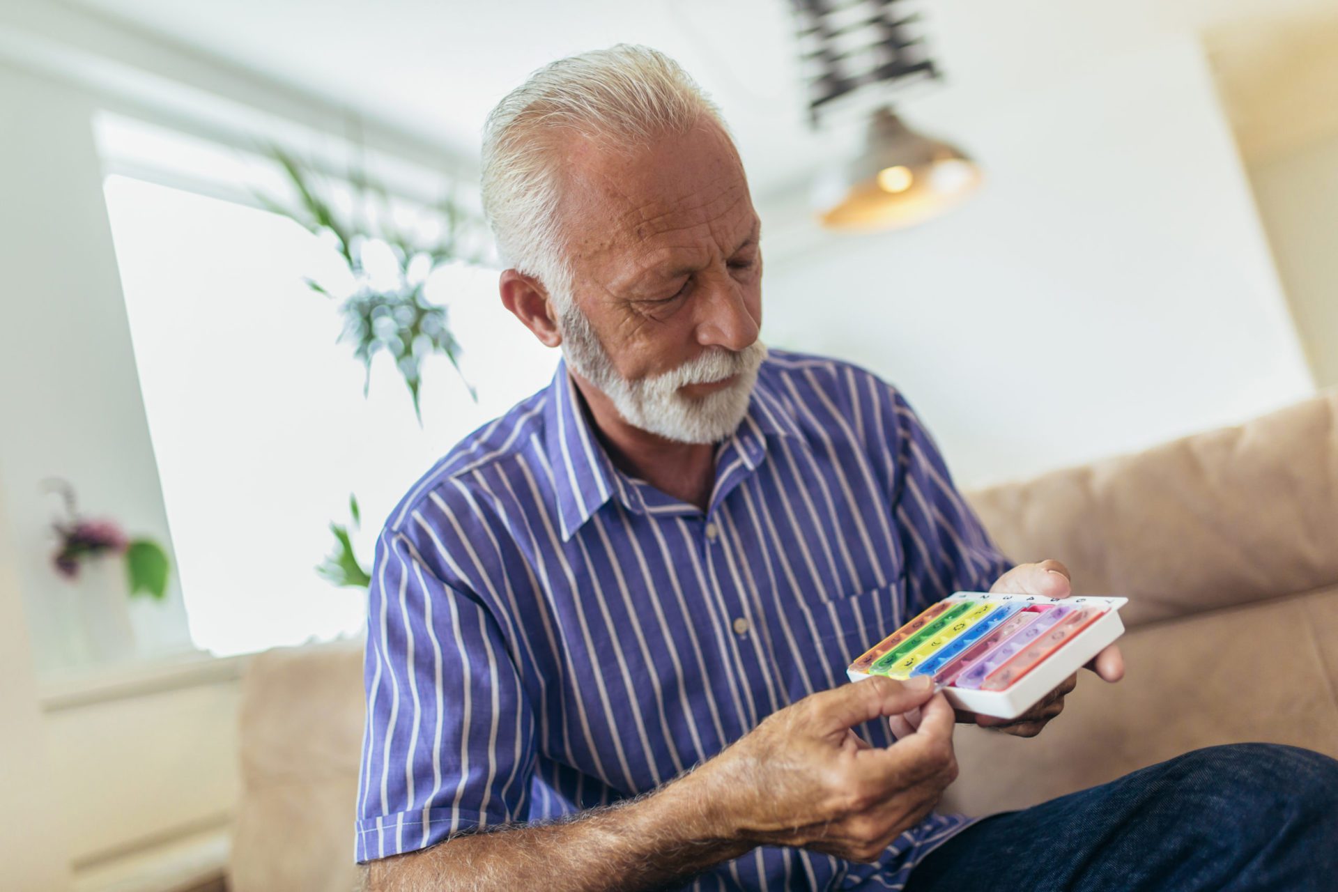 Older man holding his daily medication in blister pack