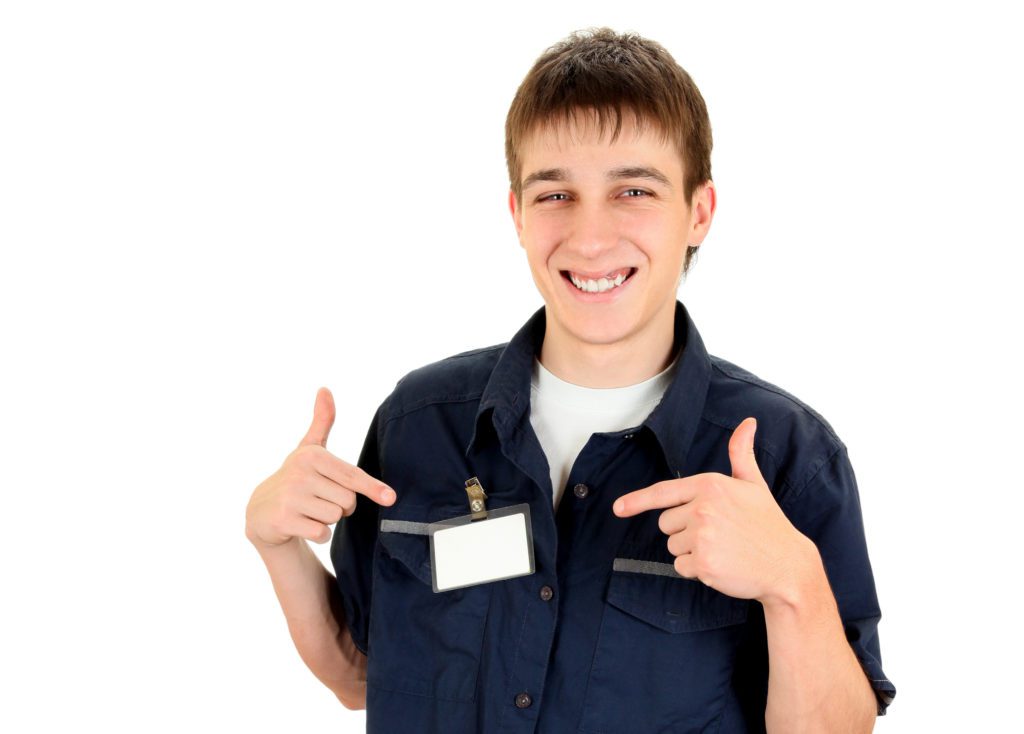 young male personal assistant proudly displays id badge clipped on chest